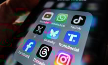 An iPhone app folder with several icons for popular social media apps, including Bluesky, X, and Truth Social.