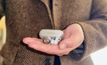 close-up of man holding panasonic technics az100 wireless earbuds with silver charging case