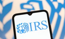 A phone screen displaying a light blue IRS logo. 