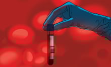 A scientist's hand holding a vial of blood.