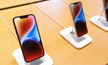 Apple iPhone 14 models standing on a table.