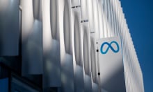 A sign with the Meta logo on the side of a large white building.