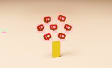 yellow smartphone on an orange background with red social media like buttons above it