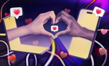 two hands reaching out of laptops to form a hand heart