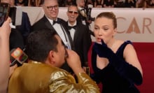 A man and a woman on the Oscars red carpet take a shot of tequila.