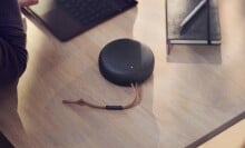 a black bang & olufsen beosound a1 speaker on a wood desk