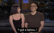 A man and a woman stand on a stage.