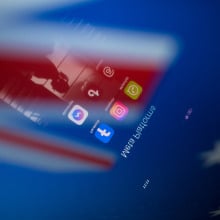 Social network logos display on a smartphone screen and the Australian flag appears on a computer screen in this photo illustration in Athens, Greece, on November 21, 2024. The Australian government proposes a ban on social media for all citizens under 16. Citing the success of recently introduced restrictions on mobile phones in Australian schools, the prime minister announces the ban by declaring that it is doing harm to children and he is calling time on it.