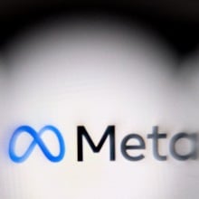 The Meta logo on a blurred computer screen.