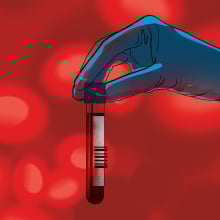 A scientist's hand holding a vial of blood.