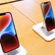 Apple iPhone 14 models standing on a table.