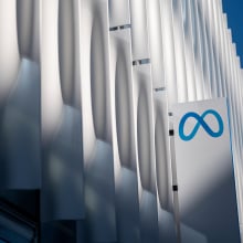 A sign with the Meta logo on the side of a large white building.