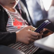 A young girl looks at her smartphone.