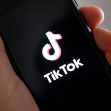 a hand hold a smartphone with the tiktok logo on it 