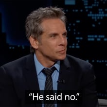 A man in a suit sits on a talk show sofa, smiling. The caption at the bottom reads "He said no."