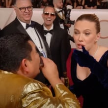 A man and a woman on the Oscars red carpet take a shot of tequila.