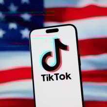 the tiktok logo on a phone in front of the american flag