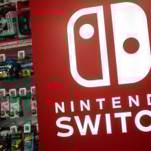 A red Nintendo Switch sign in front of a display of Switch games.