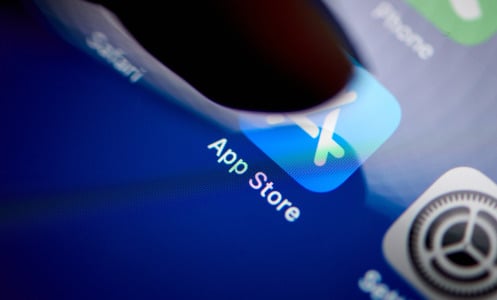 A finger taps on the Apple App Store app on a phone screen. 