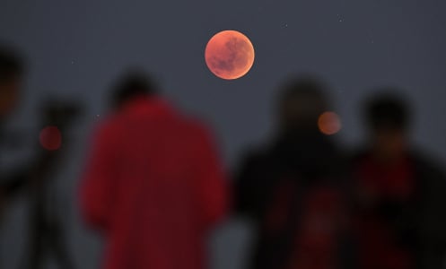 People witnessing a total lunar eclipse in Melbourne, Australia on July 28, 2018.