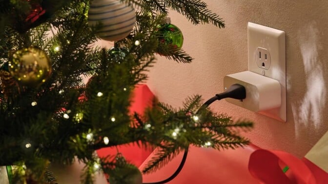an amazon smart plug sits in an outlet behind a Christmas tree