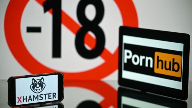 screens displaying an age restriction warning sign and the logos of the pornographic sites Pornhub (R) and Xhamster (L)