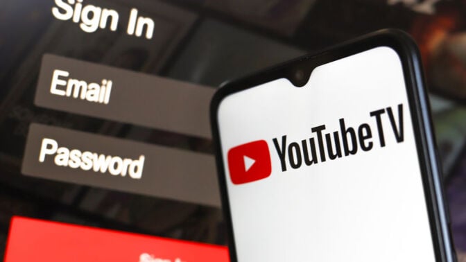 youtube tv logo on a smartphone in front of a youtube sign in page on a computer screen