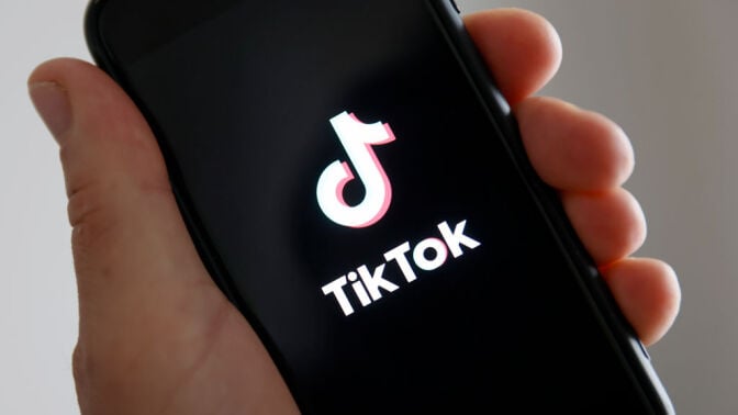a hand hold a smartphone with the tiktok logo on it 