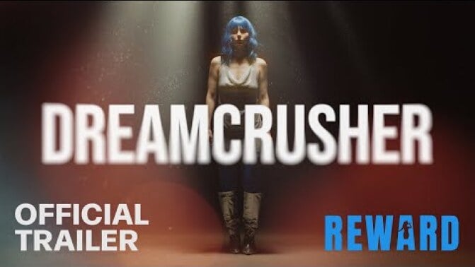 A woman in a blue wig behind the text "Dreamcrusher."