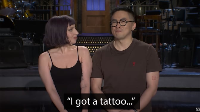 A man and a woman stand on a stage.