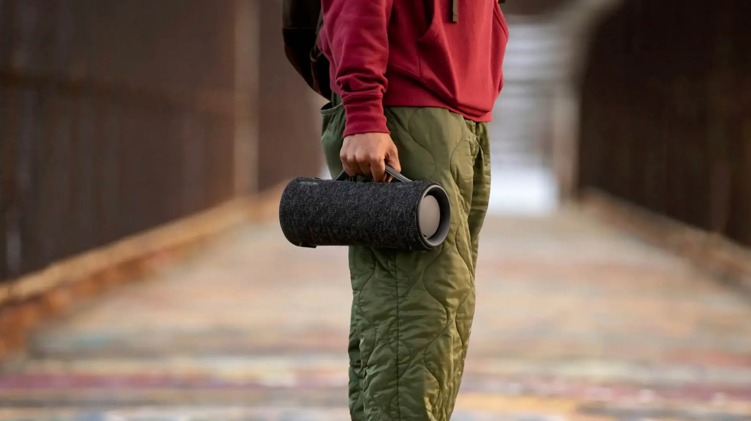 Person standing in the street and holding the Sony XG300 portable Bluetooth speaker. 