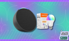 An image showcasing a Black Friday/Cyber Monday deal featuring a charcoal-colored Amazon Echo Pop smart speaker and a box of Amazon Basics smart bulbs against a colorful teal and purple background.
