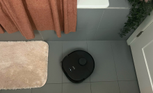 Eufy X10 Pro Omni robot vacuum mopping gray tile floor by bathtub