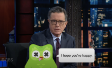 Stephen Colbert presents "The Late Show" with a cartoon of Duo the Owl overlaid on the screen.