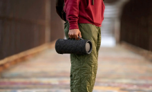 Person standing in the street and holding the Sony XG300 portable Bluetooth speaker. 