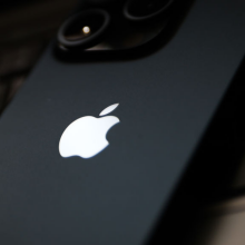 A laptop keyboard and Apple iPhone 15 Pro.