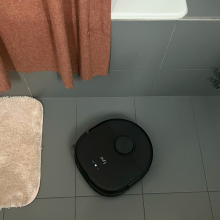 Eufy X10 Pro Omni robot vacuum mopping gray tile floor by bathtub