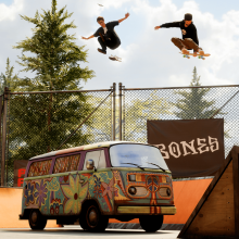 Two skateboarders perform tricks over a colorful van in a skate park with branded banners and ramps.