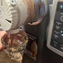 A person dispensing soft serve from a Ninja Swirl