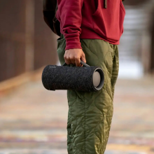 Person standing in the street and holding the Sony XG300 portable Bluetooth speaker. 