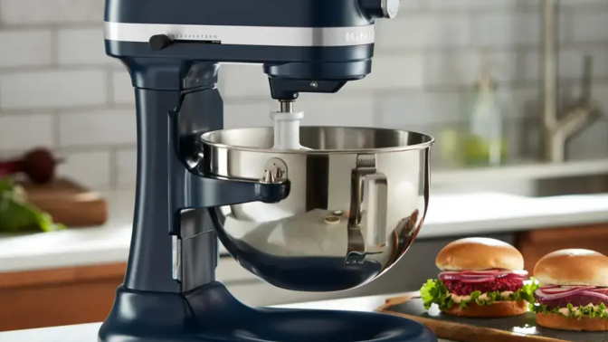 Navy blue KitchenAid stand mixer on countertop with burgers in background